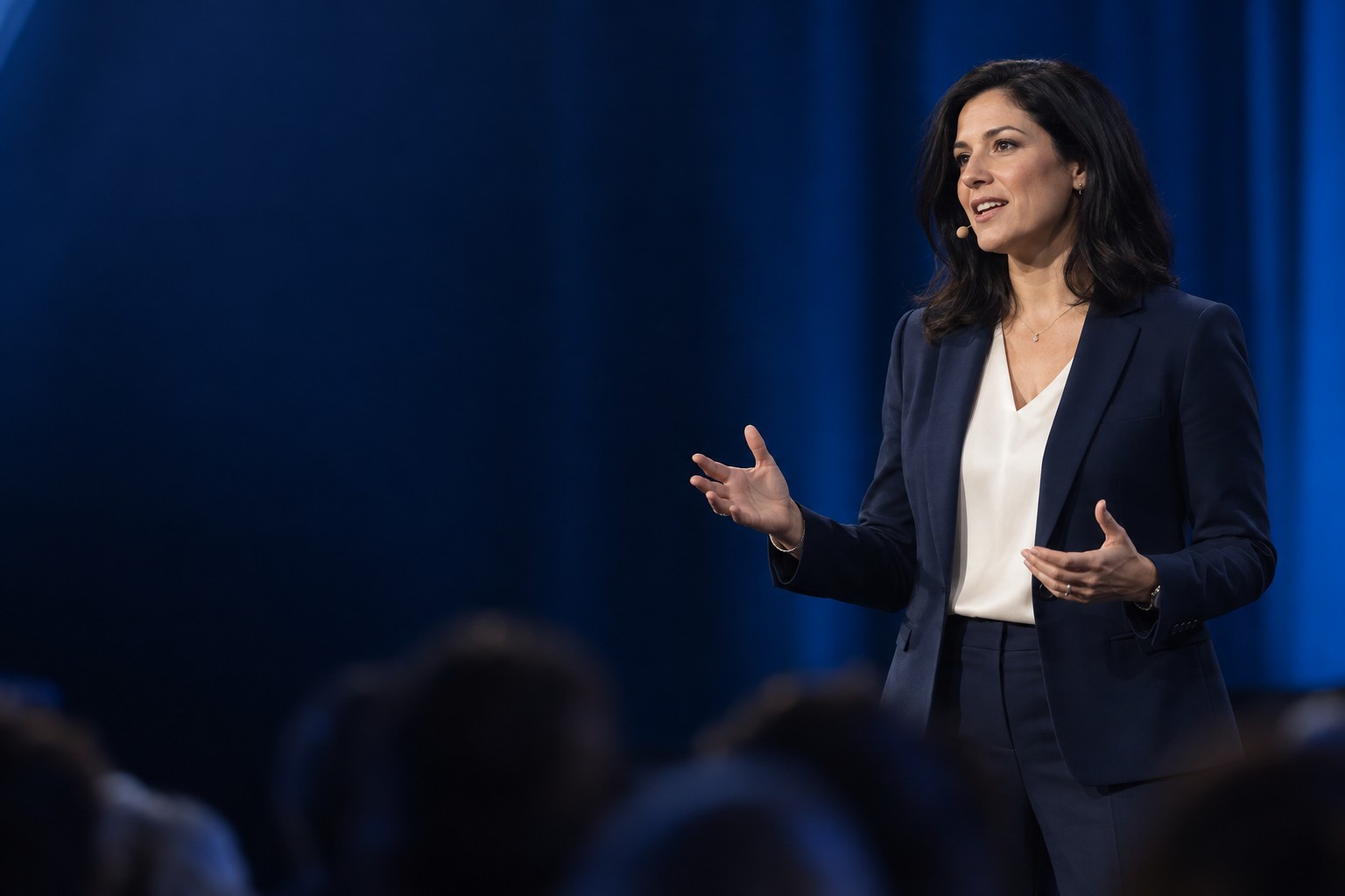 A speaker addressing an audience from a conference stage